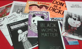 Es sind verschiedene Flyer und Heftchen mit Titelsprüchen zu sehen, die für mehr Offenheit und gegen Diskriminierung stehen. Beispielsweise "Black Women Matter" oder "OMG Lesbians".