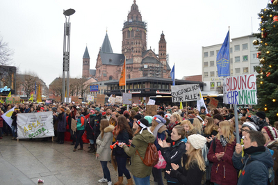 Eine Menschenmenge mit Plakaten, im Hintergrund der Mainzer Dom.
