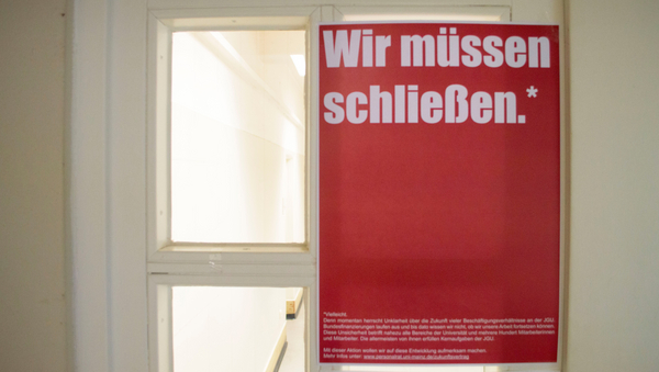 Ein rotes Plakat der Aktion "Wir müssen schließen" hängt an einer geschlossenen Tür.