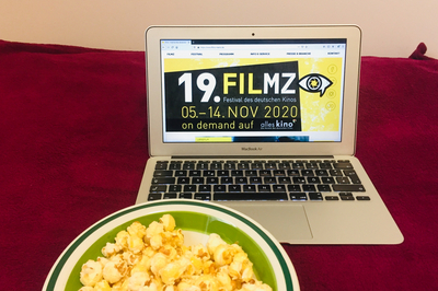 Laptop mit FILMZ-Logo und Popcorn.