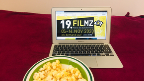 Laptop mit FILMZ-Logo und Popcorn.