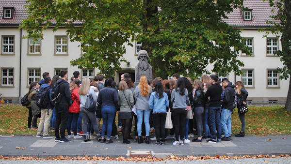 Eine Gruppe von Erstis vor der Johannes Gutenberg-Statue. 
