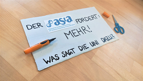 Ein Schild mit der Aufschrift "AStA fordert: MEHR! Was sagt die Uni sazu?"