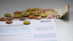 Im oberen Bereich des Bildes ist ein zehn Euro Schein zu sehen. Unterhalb des Geldscheins liegt ein Antrag auf BAföG. Über den zehn Euro Schein und den Antrag auf BAföG liegen verschiedene Geldmünzen verteilt.