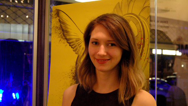 Eine junge Frau vor einem gelben Plakat