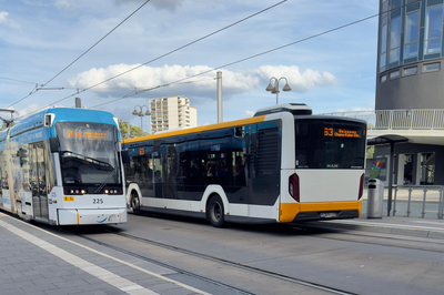 Zu sehen sind eine Straßenbahn und ein Bus der Mainzer Mobilität. Die Haltestelle ist Hbf West / Taubertsberg Bad + Spa.