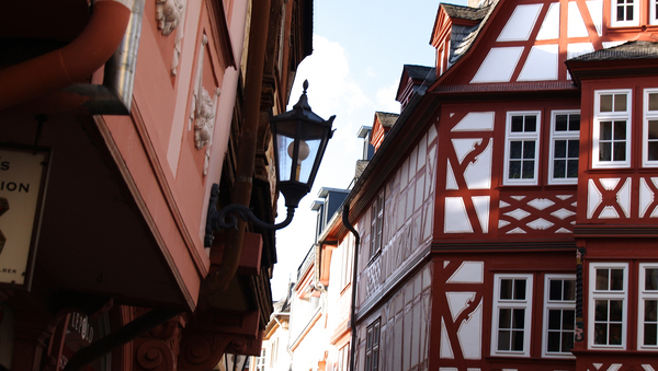 Blick auf eine Gasse in der Mainzer Altstadt. Man sieht Altbau- und Fachwerkhäuser.