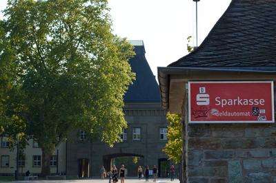 Sparkassenschild im Vordergrund - im Hintergrund der Eingang zur Universität Mainz