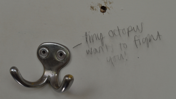 Ein silberner Jackenhaken. Daneben die Worte "tiny octopus wants to fight you".