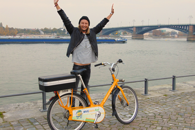 Mann neben Fahrrad auf Rheinpromenade