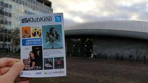 Das Programmheft des KlubKino im Wintersemester 2022/2023 vor dem Gebäude "die Muschel".