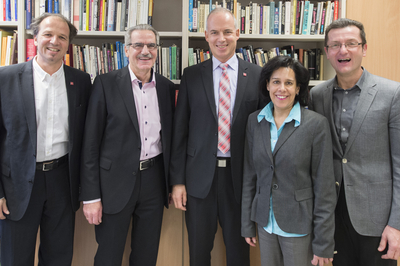 Fünf Professoren der JGU vor einem Bücherregal, unter Ihnen der Präsident der Uni.