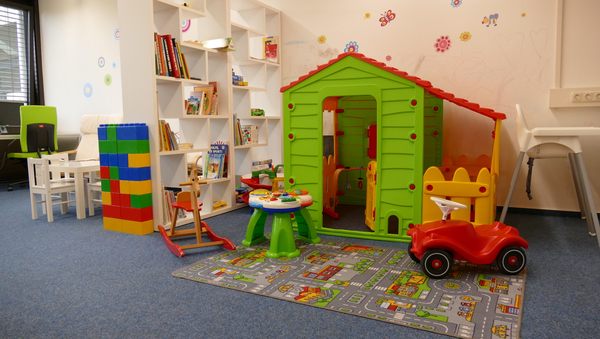 Spielecke mit Bücherregal, Bobbycar, Bauklötzen und weiteren Spielzeugen für Kinder