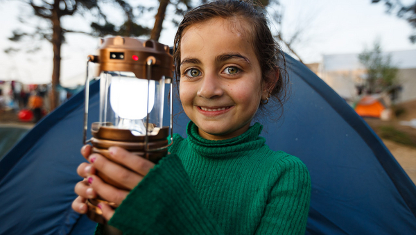 Ein lächelndes Mädchen hält eine Lampe. ©David Lohmüller