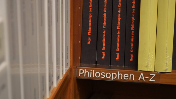 Ein Bücherregal, an dem steht "Philosophen A-Z".