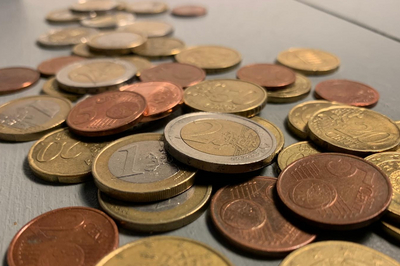 Es sind zahlreiche Cent- und Euro-Münzen zu sehen.