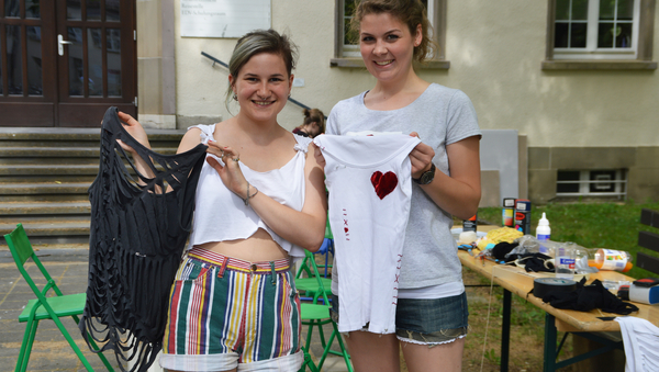 Zwei Frauen halten jeweils ein selbstgestaltetes T-Shirt in der Hand