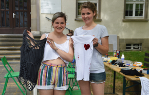 Zwei Frauen halten jeweils ein selbstgestaltetes T-Shirt in der Hand