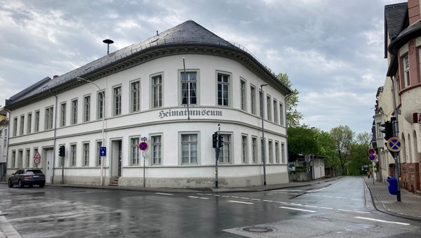 An einer Straßenecke steht ein langes, zweistöckiges Gebäude mit der Aufschrift "Heimatmuseum".