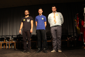 Drei Männer stehen mit geschlossenen Augen auf der Bühne. 