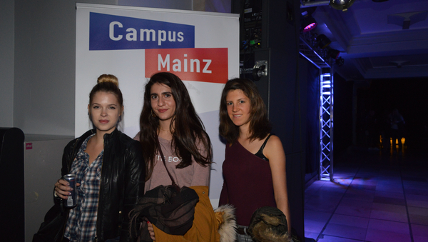 Drei Besucherinnen der ersten Uniparty vor einem Campus Mainz Banner.