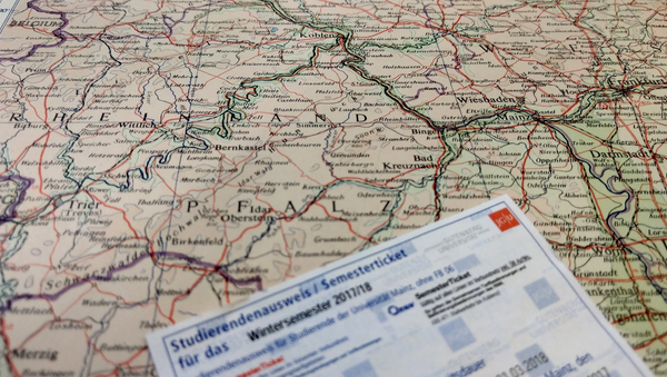 Das Semesterticket der Uni Mainz liegt auf einer Landkarte von Rheinland-Pfalz