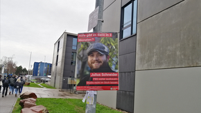 Man sieht Julius Schneider auf einem Wahlplakat der Juso-Hochschulgruppe. Dieses hängt im Jakob-Welder-Weg auf dem Campus der Universität Mainz.