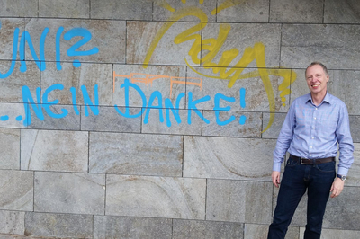 Wolfgang vor der Wand des Philosophicums mit dem Grafitti "Uni? - Nein Danke"
